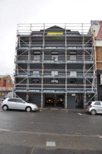 gray commercial building with scaffolding setup